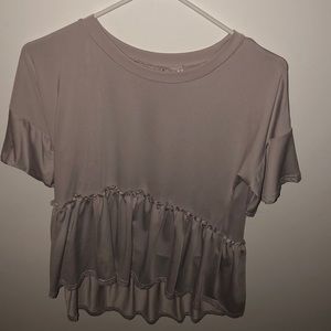 a pink stretchy blouse that has ruffles